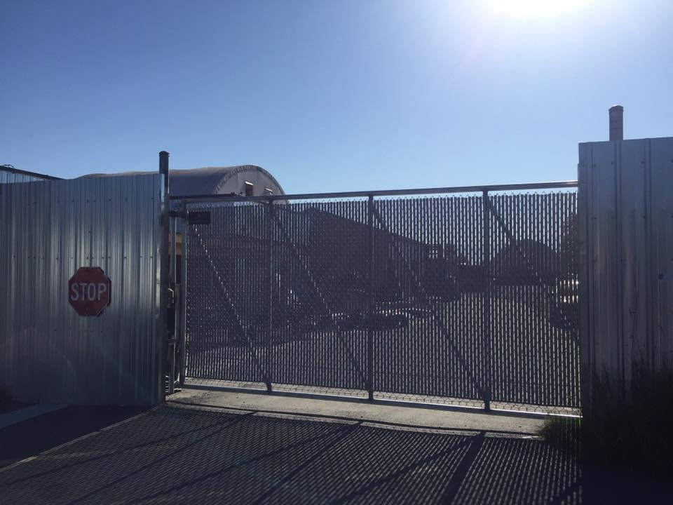 8-foot by 16-foot galvanized cantilever slide gate with grey privacy slats securing an Abbotsford industrial yard — White Rock, BC commercial project.