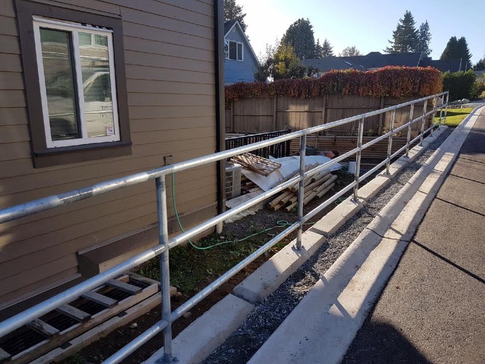 Galvanized pipe MMCD-spec handrail installed along an accessible driveway ramp in Maple Ridge BC