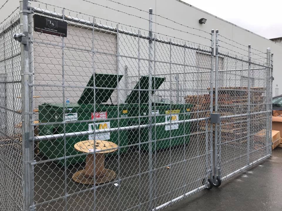 Galvanized chain link strata waste and compactor enclosure with three-strand barbed wire topping and a cantilever sliding gate in Abbotsford BC