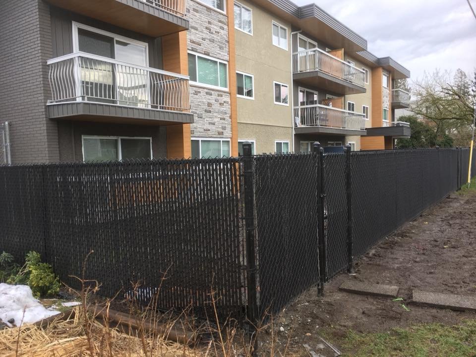 Black chain link fence with privacy slats installed in Maple Ridge BC