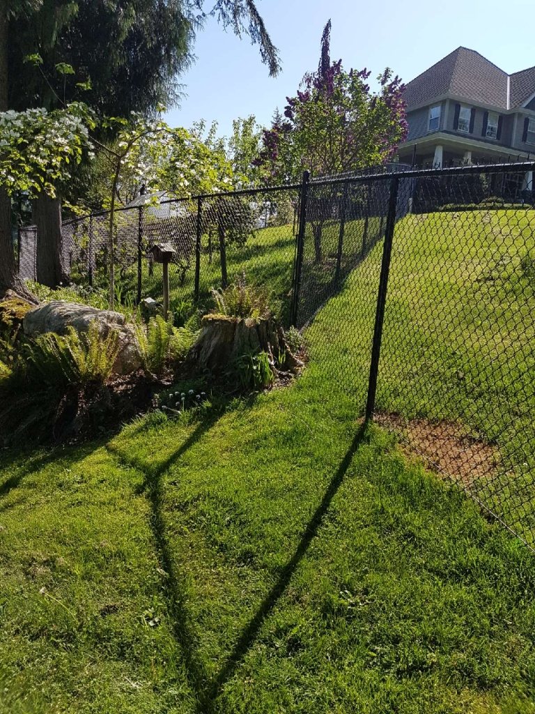 Black chain-link fence following a landscaped slope — photograph supplied by LS Fencing & Metal Work
