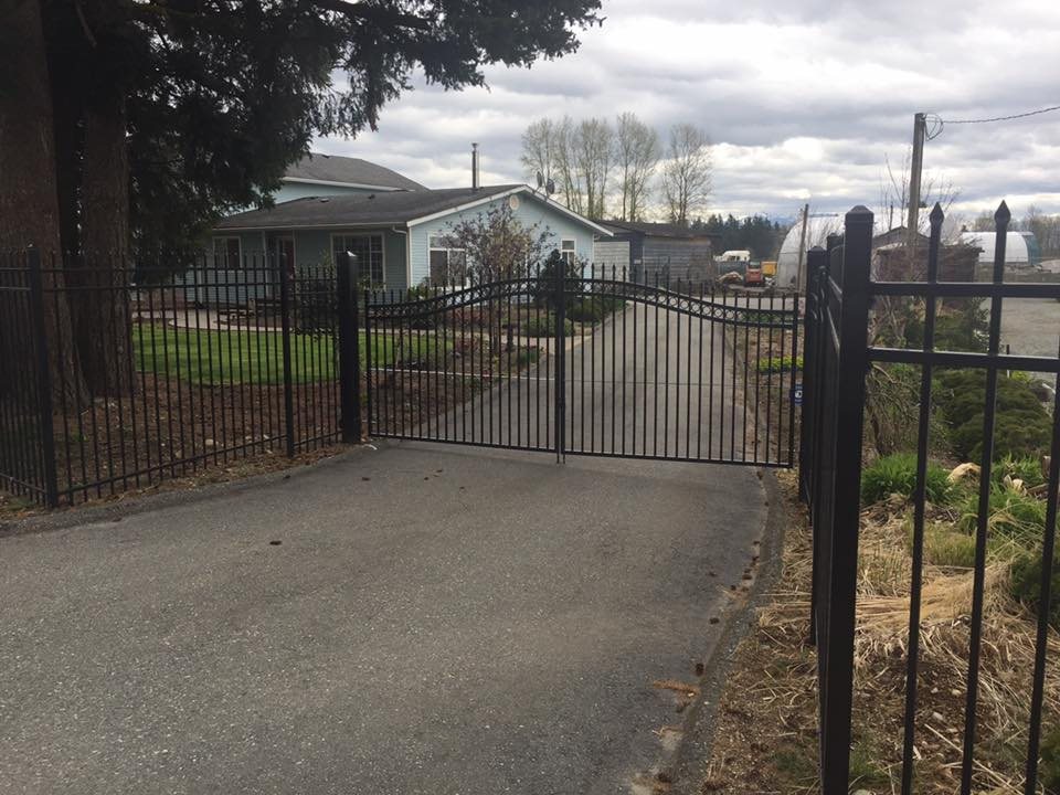 Ornamental gate at a landscaped entrance — photograph supplied by LS Fencing & Metal Work