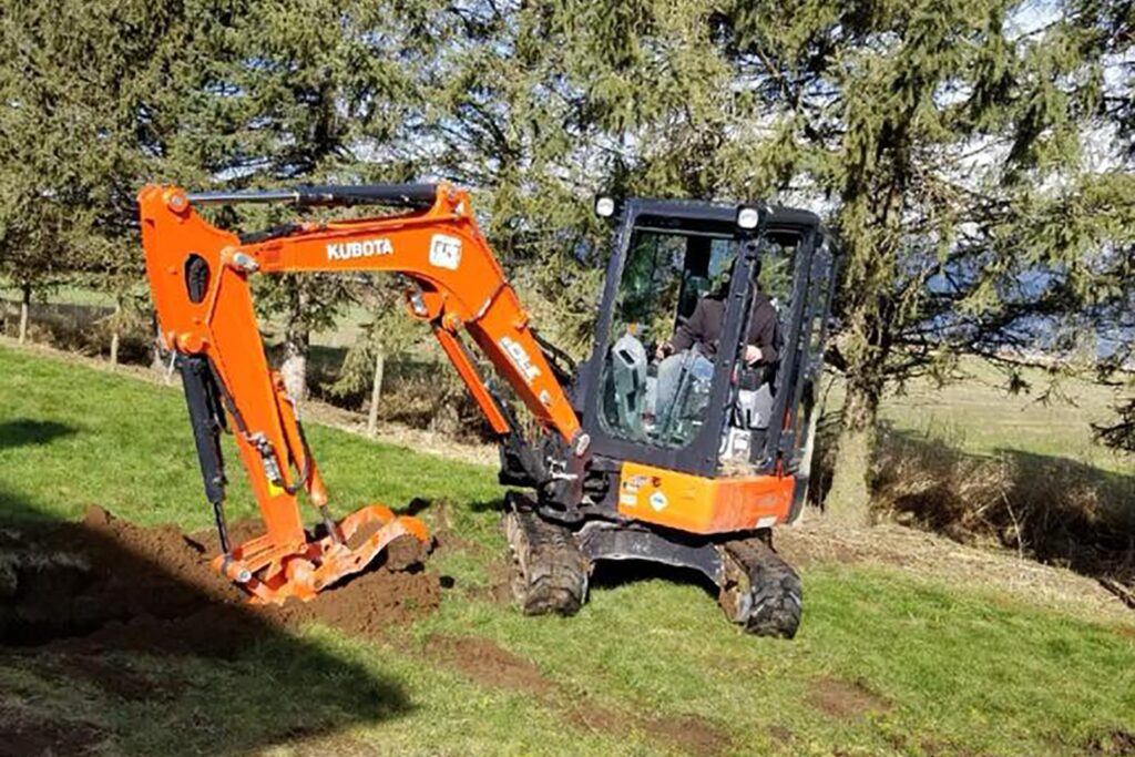 Skid steer leveling gravel for landscape preparation