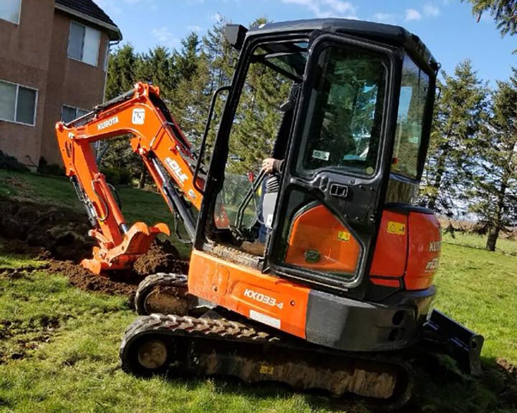 Bobcat digging trench on residential property